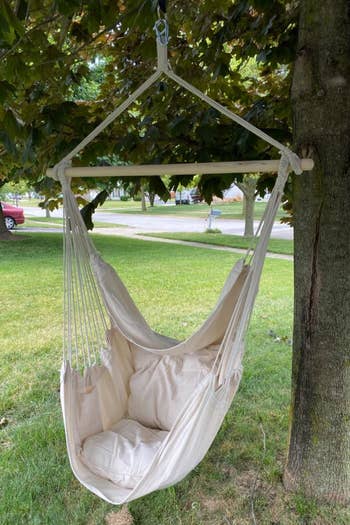 a reviewer photo of a swinging chair hung from a tree 