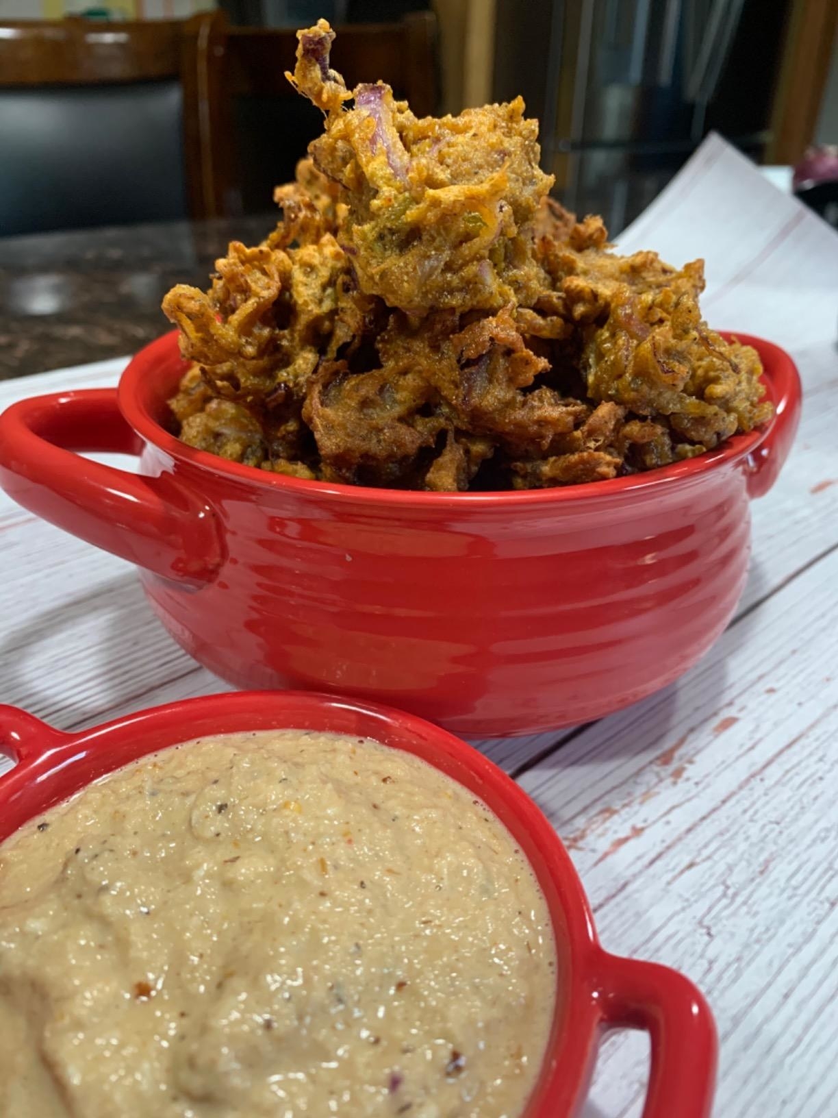 reviewer image of a red cutiset ceramic bowl full of a fried onion stack