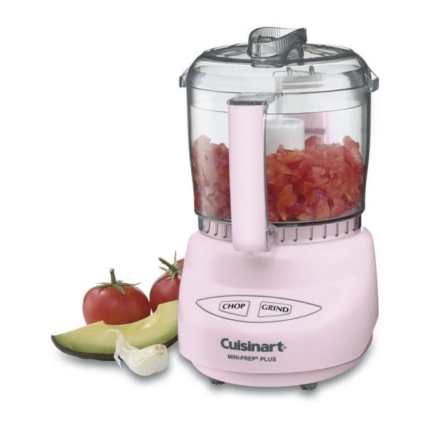 A pink food processor with tomatoes in it