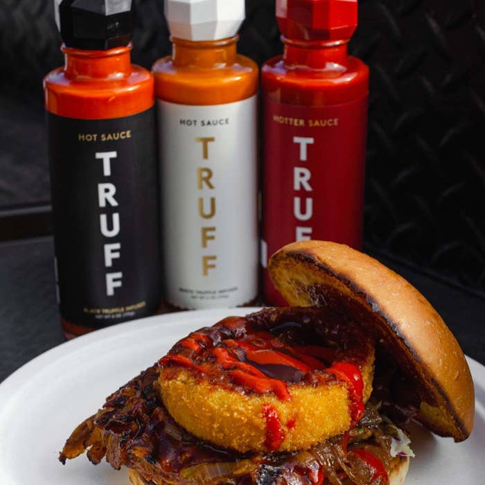 All three Truff hot sauces next to a BBQ sandwich with some Truff drizzled on 