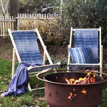 two tie dye blue chairs around a fire pit
