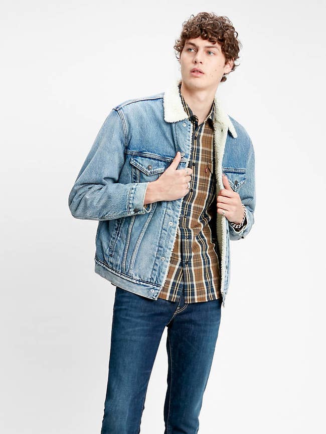a model in a blue denim jacket lined with white sherpa