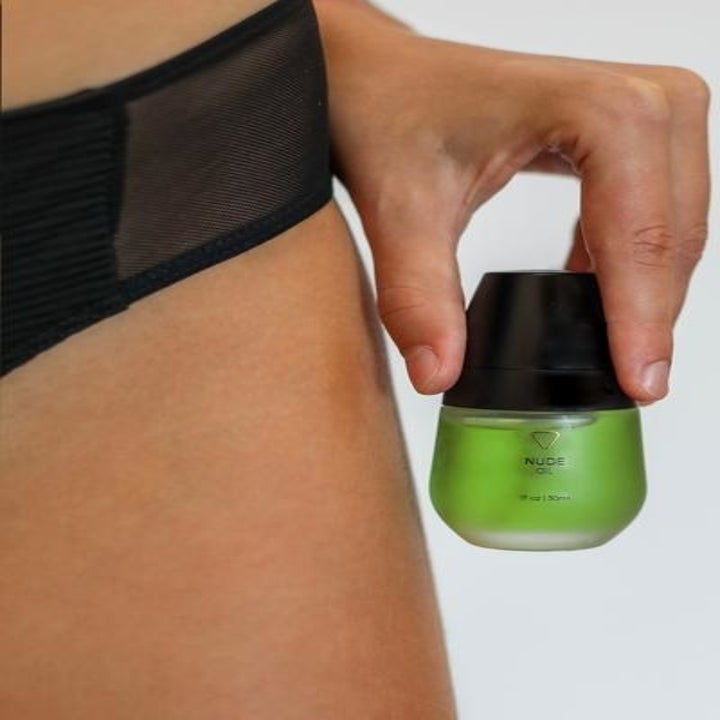model holding oil bottle next to their bikini line