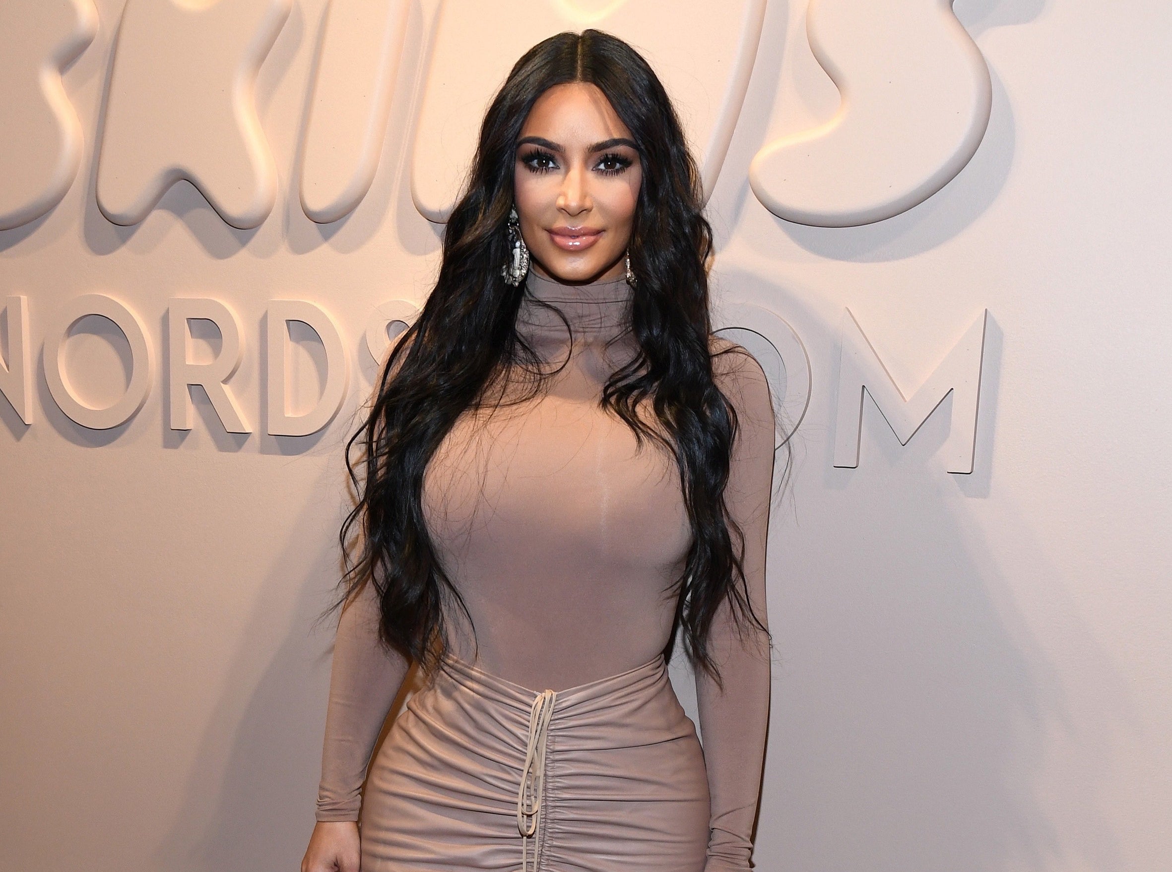 Kim wears a tight fitting turtleneck top to a Skims event