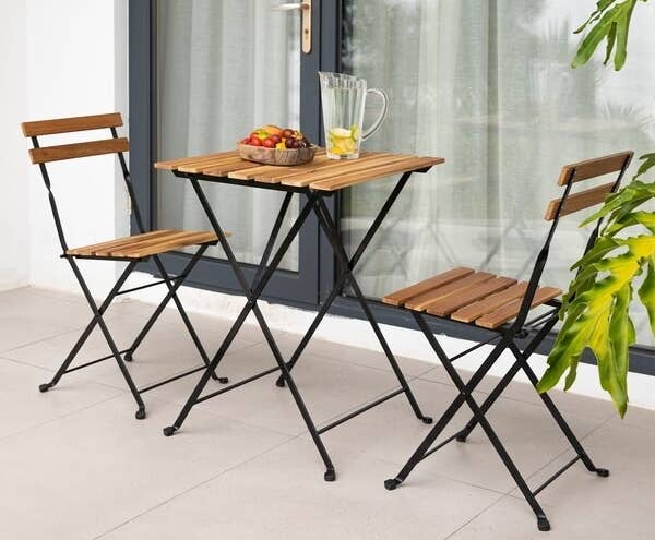 a wooden table and two matching folding chairs 