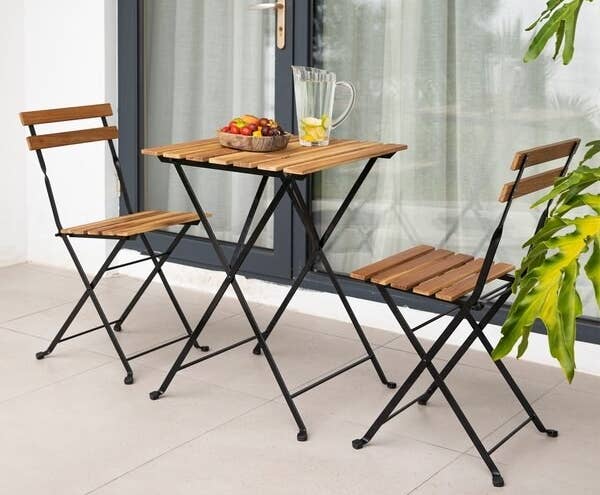 a wooden table and two matching folding chairs