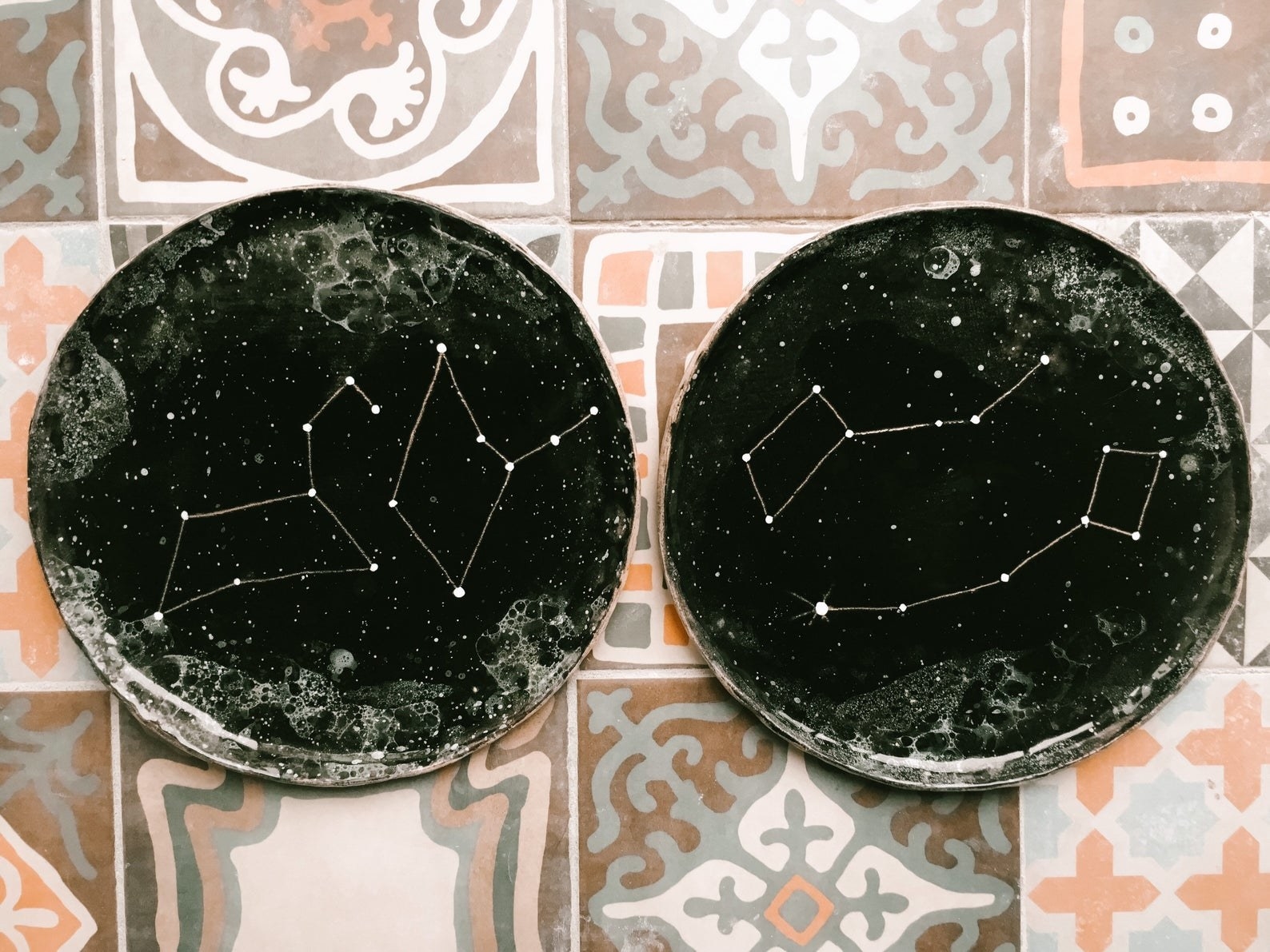 two ceramic constellation plates side by side