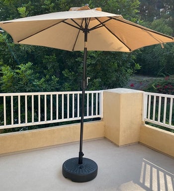 a reviewer photo of the umbrella on a patio in tan 