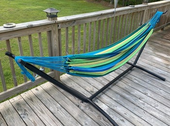 a striped free-standing hammock on a patio 