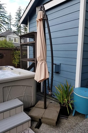 a reviewer pf the hanging umbrella on the included stand folded down 