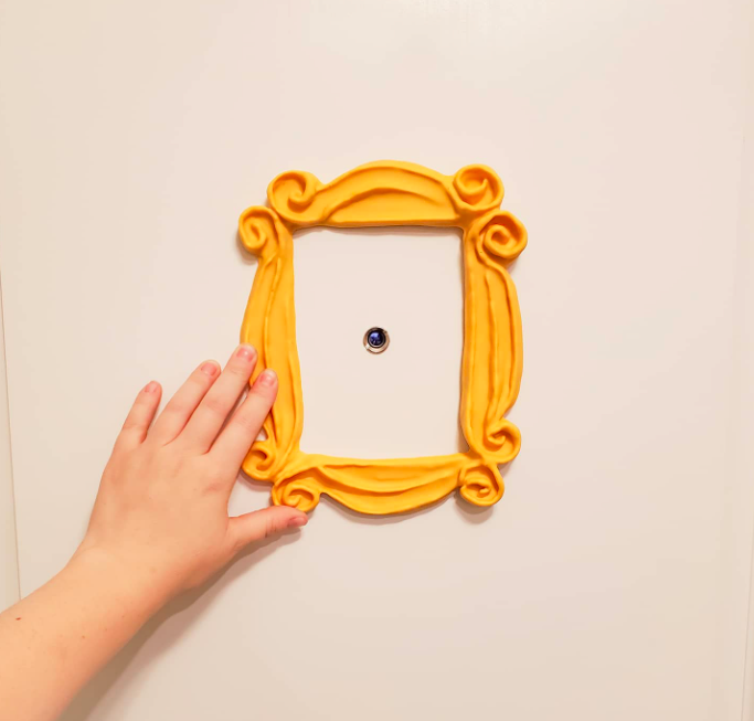 A customer review photo of them holding up the frame around their peep hole