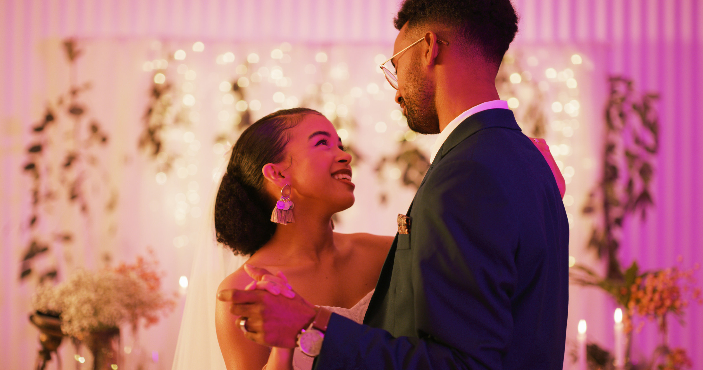 A smiling couple dancing and gazing at each other