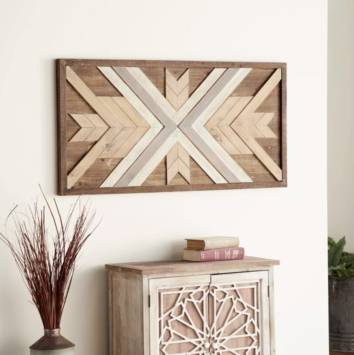 The white, gray and brown hues are in a crisscross chevron pattern in the large rectangualr wood wall decor