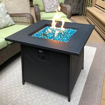 reviewer's fire pit lit up on their patio 