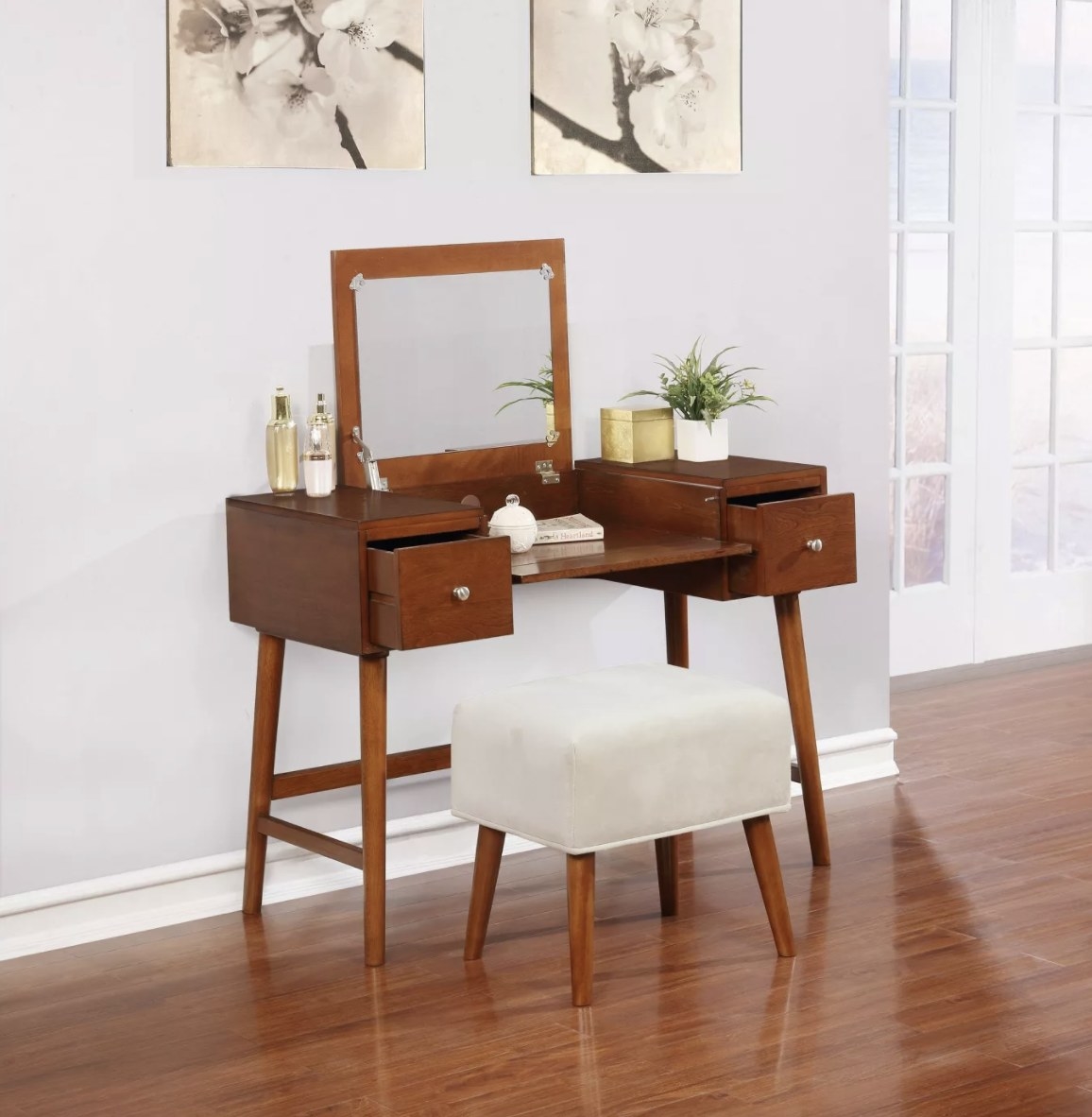 The rich brown vanity with silver handles has a white velvet stool and a flip top mirror