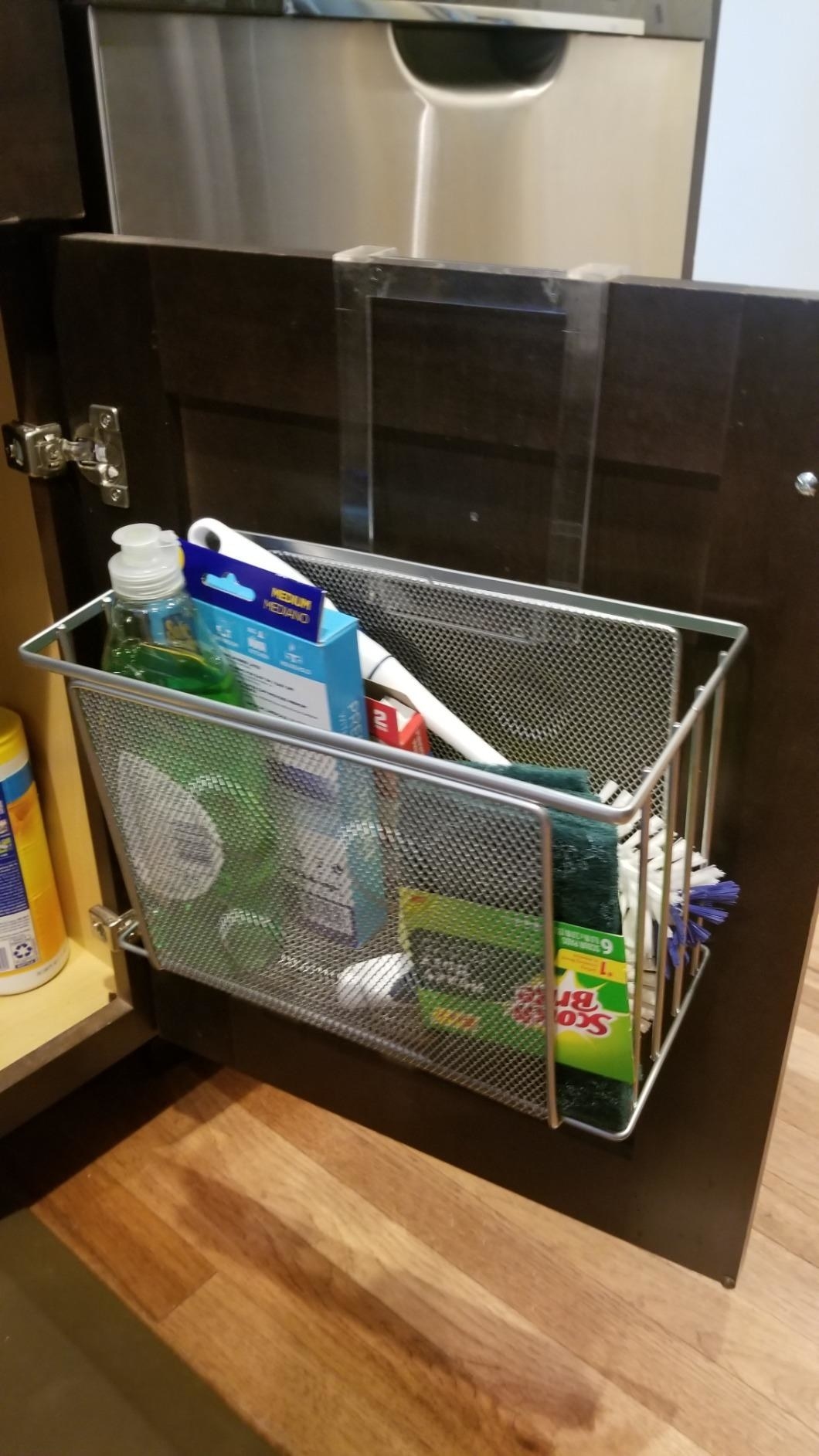A reviewer photo of the organizer hung over an under-sink cabinet door