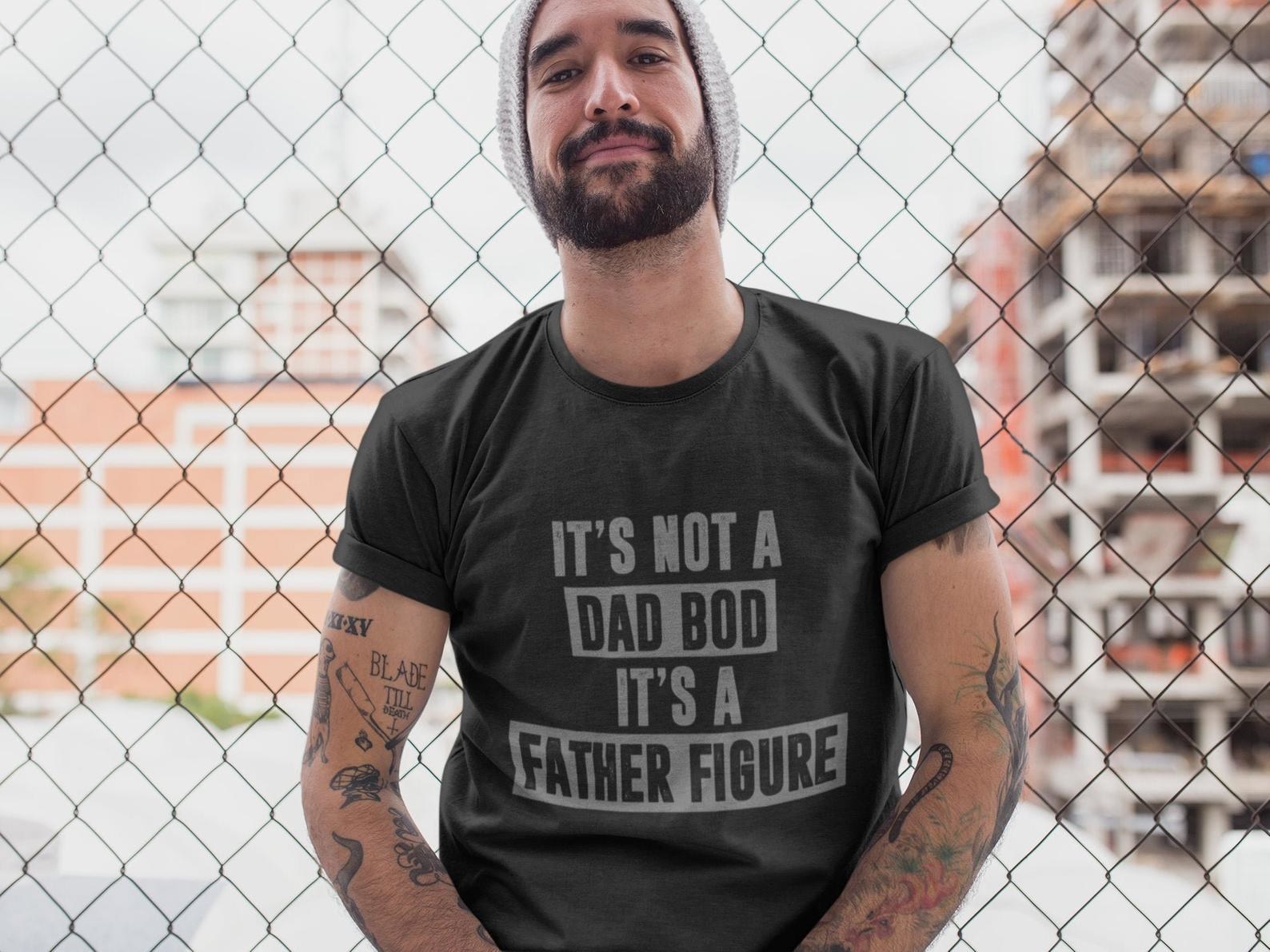 a model in a gray tee that says it&#x27;s not a dad bod it&#x27;s a father figure