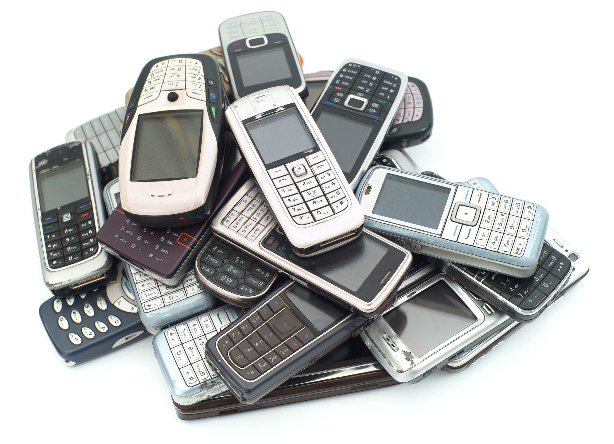 A pile of old used cellphones on a white background