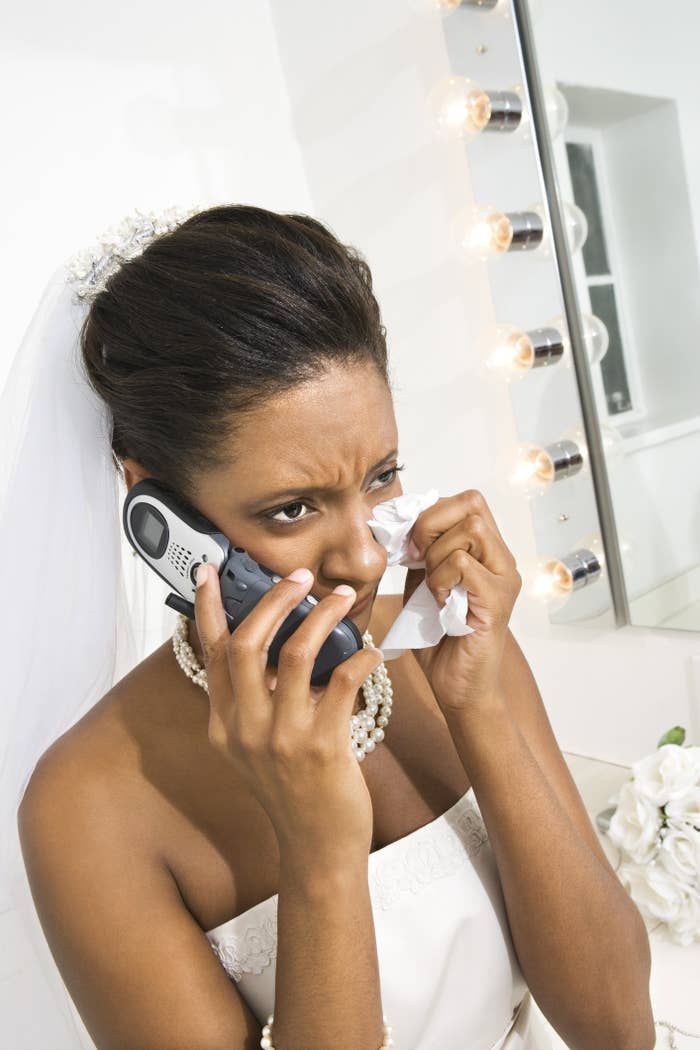 A sad bride tries calling someone on her phone