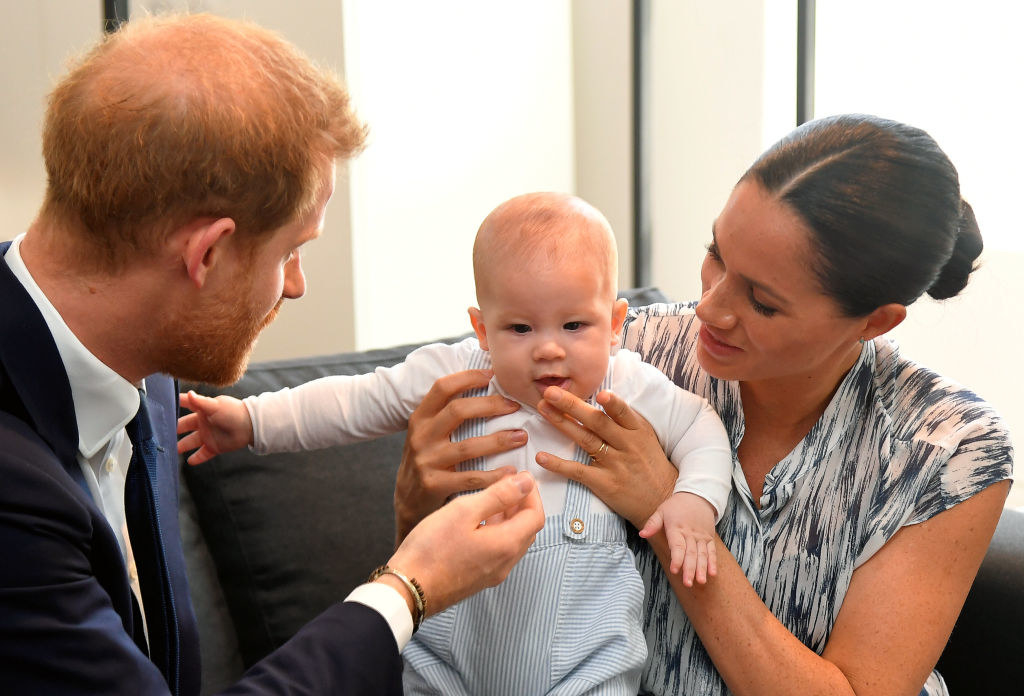 Prince Harry (L) and Meghan Markle tend to their baby son Archie Mountbatten-Windsor 