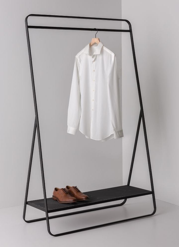 The black rack with a shirt hanging and shoes on the shelf