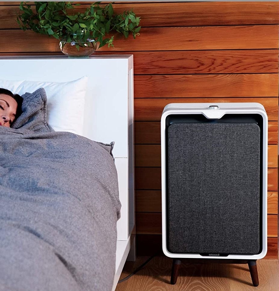 The air purifier next to a bed