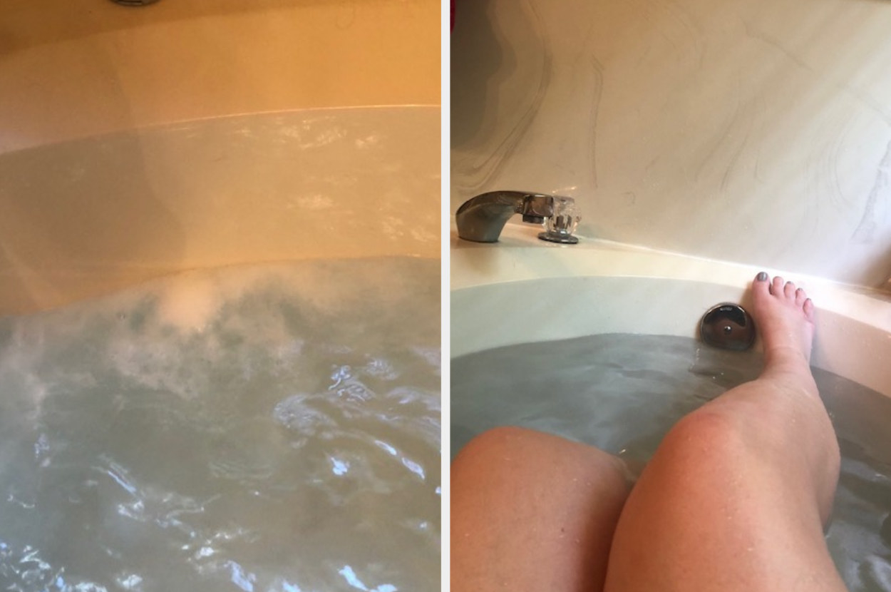 A bath bomb fizzing, next to legs in the bath