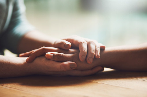 Two people&#x27;s hands clasped together. 