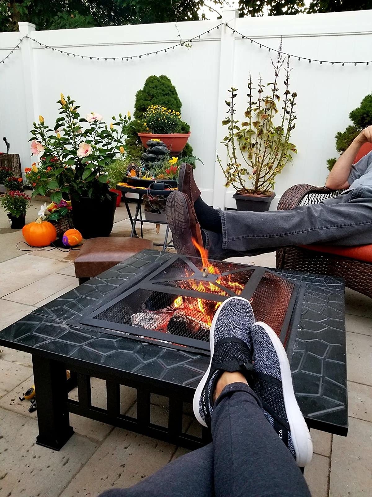 a reviewer with their feet kicked up on the edge of a fire pit