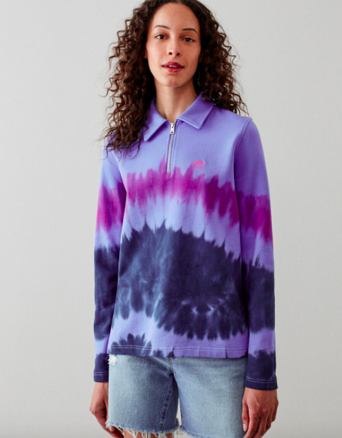 A person rocking the tie-dyed polo style sweatshirt with denim shorts