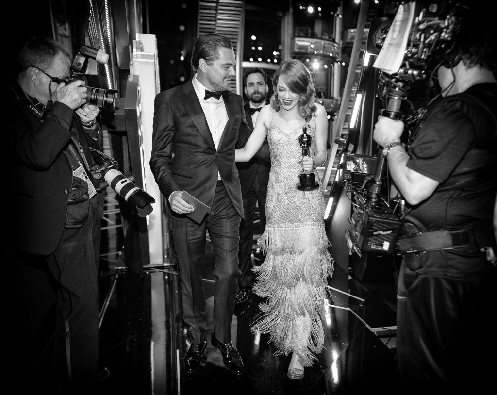 Black and white photo of Leonardo DiCaprio and Emma Stone walking backstage at the 2017 Oscars