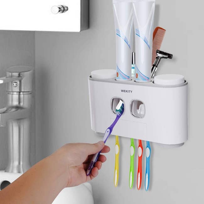 Model holding toothbrush up to automatic toothpaste dispenser