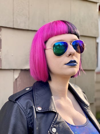 reviewer wearing the blue green aviator sunglasses