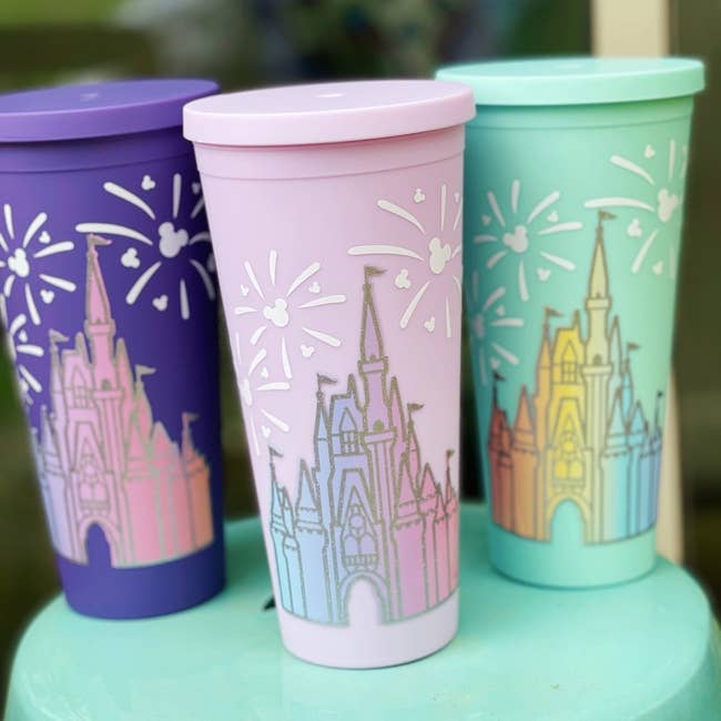 three cups in different colors with he castle in ombre on them