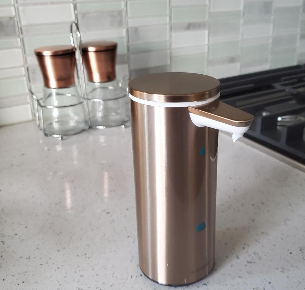 The rose gold pump soap dispenser on a kitchen counter