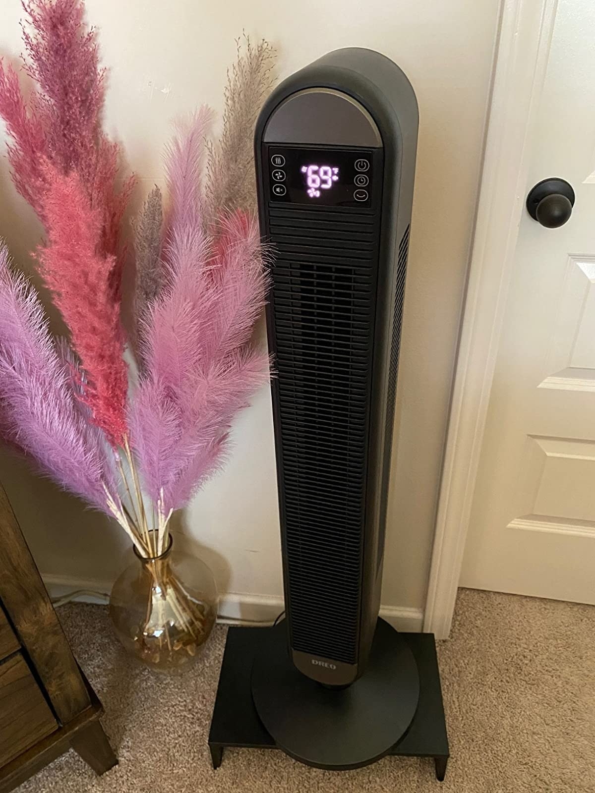 The narrow tower fan with a digital display on a rotating base in a reviewer&#x27;s bedroom