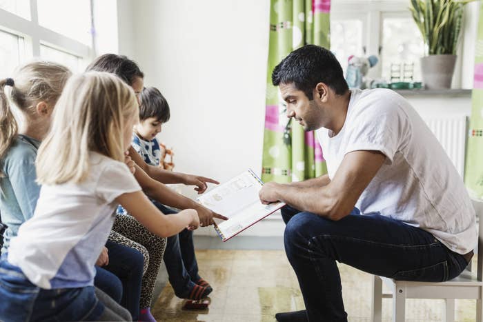 A teacher reading a book to young children
