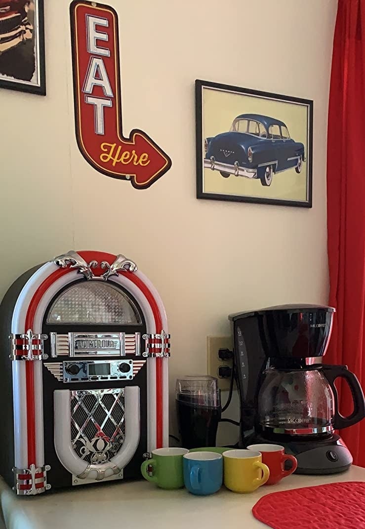 The jukebox sitting on the counter in a 50's themed room