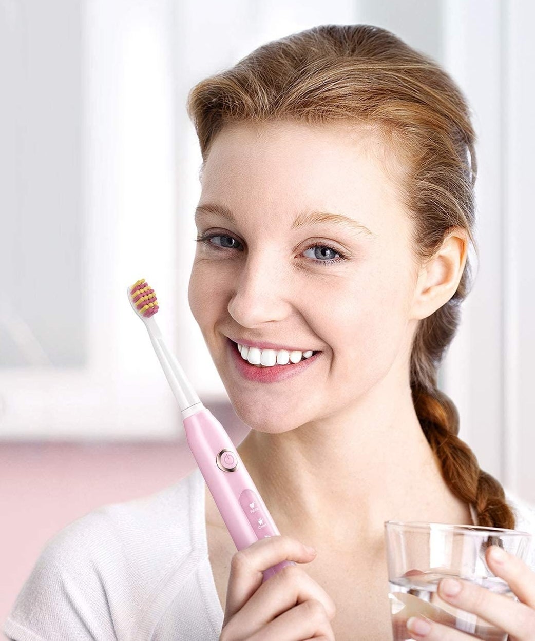 person with the toothbrush and the glass of water