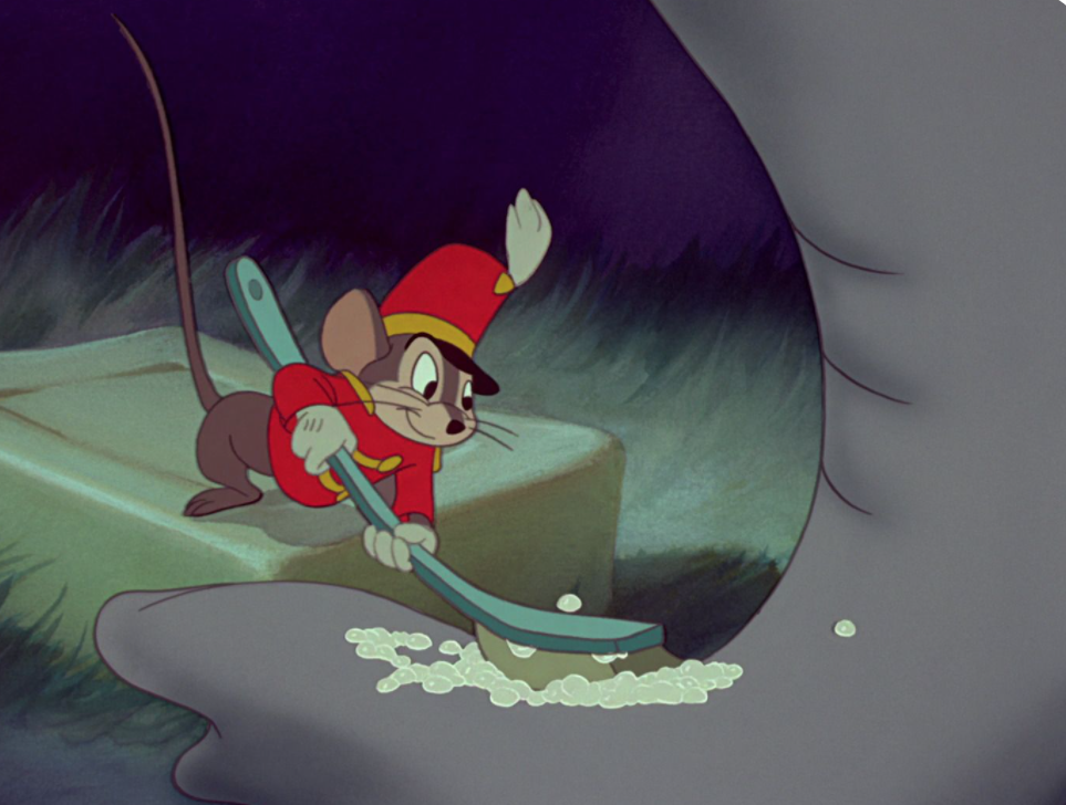 Timothy Mouse uses a small scrub brush to check the trunk of Dumbo the elephant.