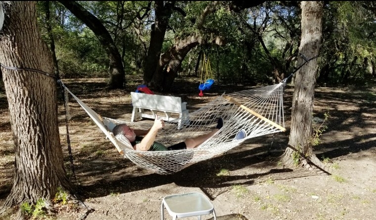 A reviewers in the traditional hammock tied between two trees 