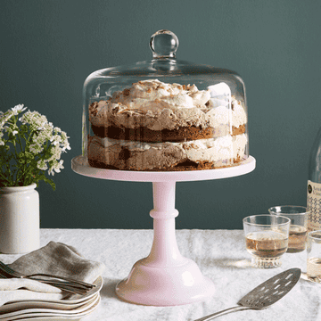 Gif of the cake stand with a cake on it, rotating through a variety of colors, with a model taking the lid on and off