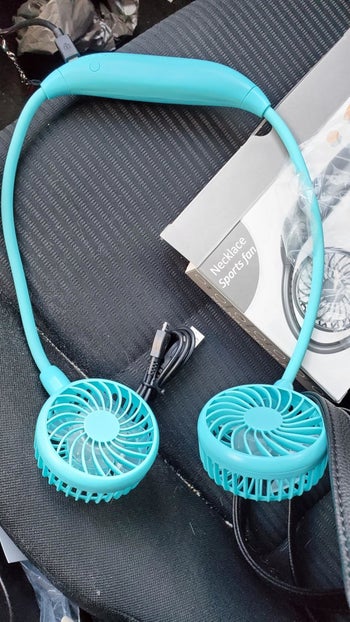 reviewer photo of a bright blue neck fan 