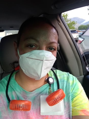 photo of a reviewer wearing an orange neck fan while wearing a mask