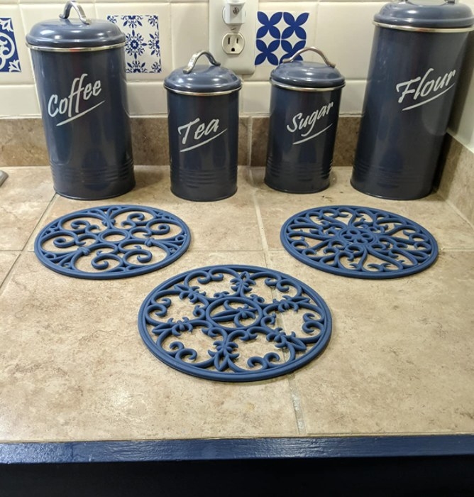 The trivets in dark blue on a reviewer&#x27;s countertop 