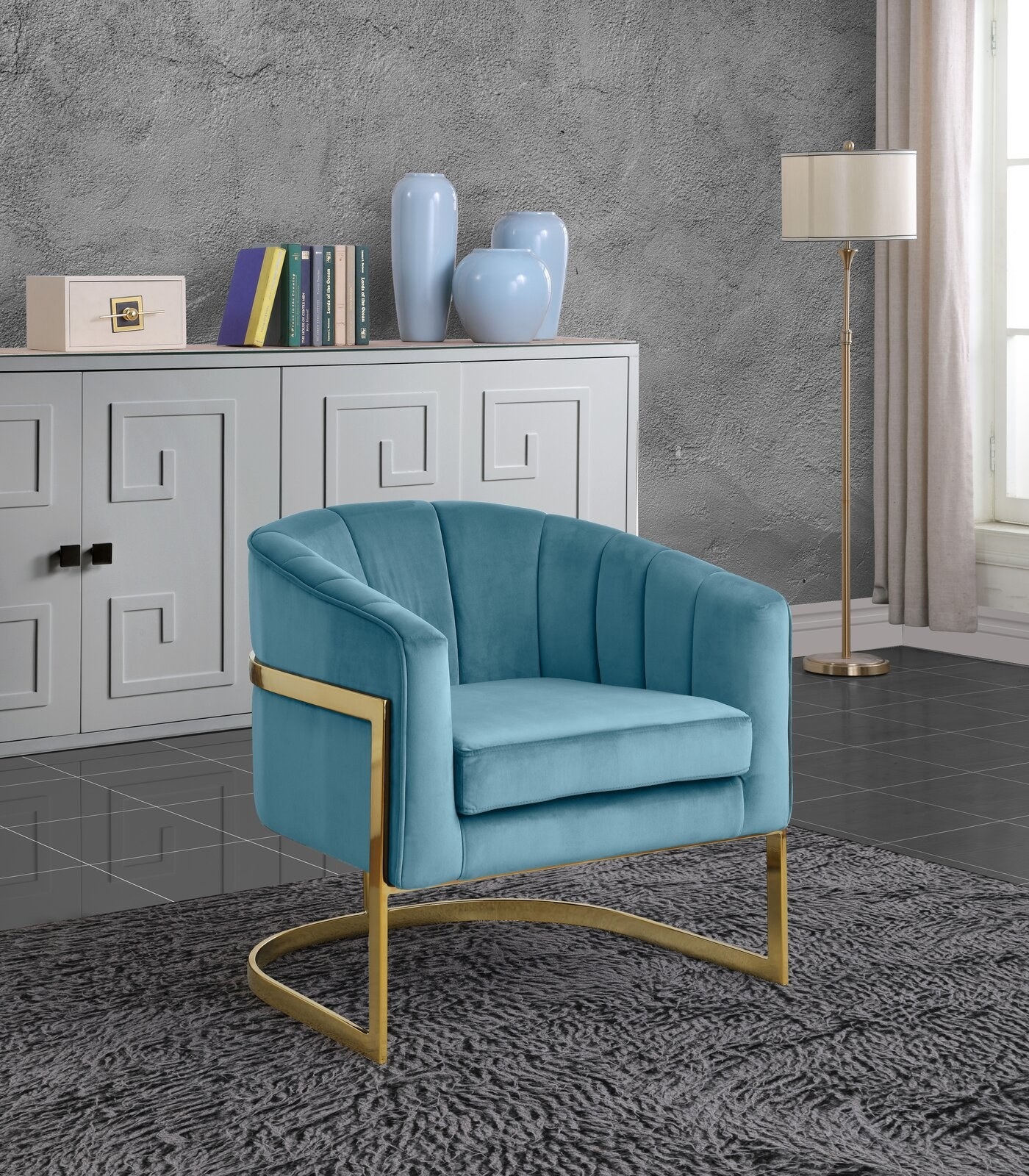 The chair, which has a &quot;U&quot;-shaped gold-tone metal base that connects to the velvet barrel seat, in aqua