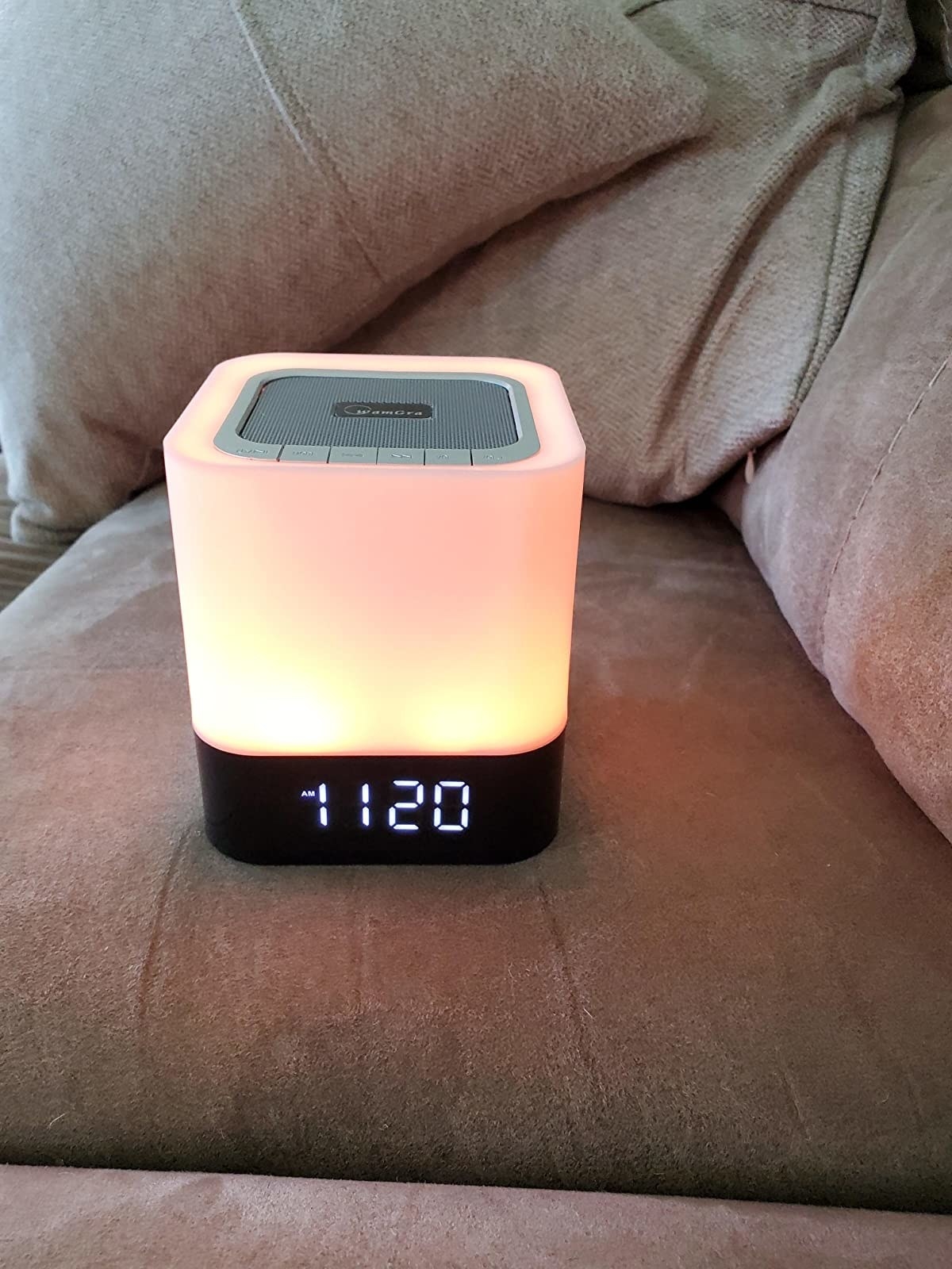 A reviewer&#x27;s speaker showing the time and glowing a warm white