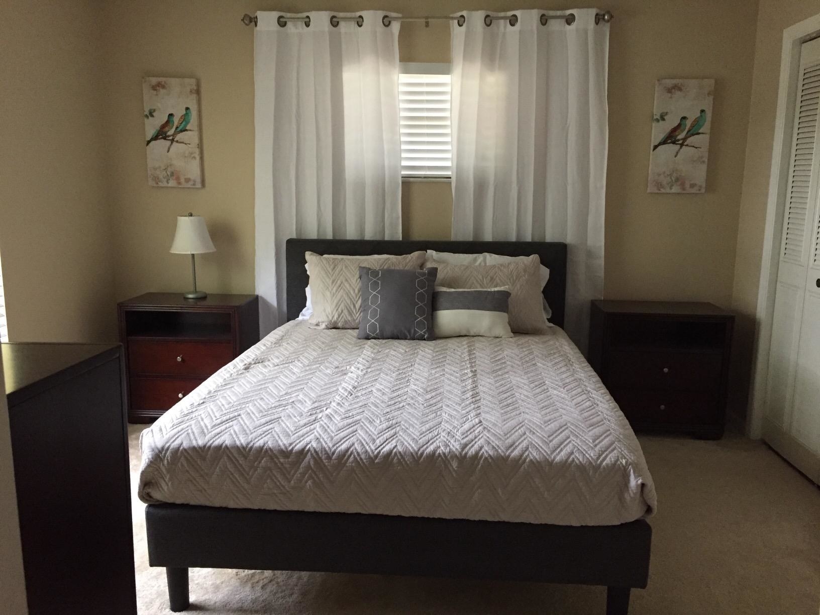 reviewer photo of a grey upholstered bed in a room