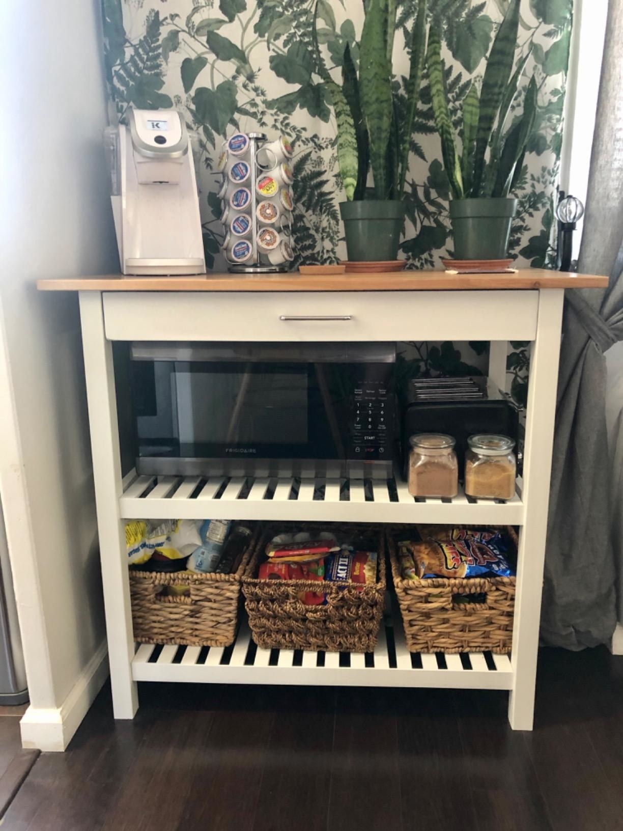 reviewer photo of a white kitchn island with two shelves, drawer, and wood top