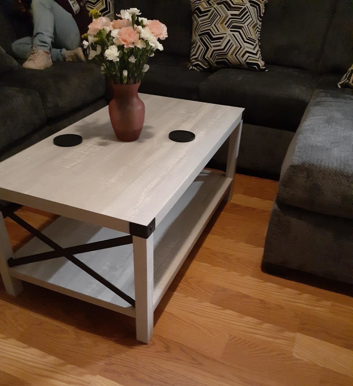 reviewer photo of rectangular farmhouse coffee table with light grey top, white legs, and metal accents